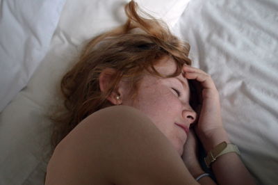 High angle view of woman lying on bed at home