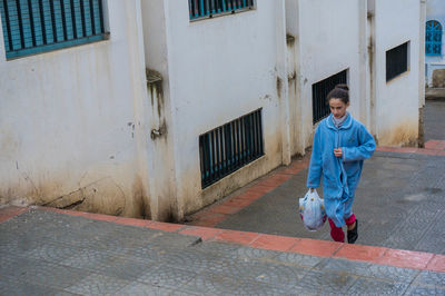 Full length of man on footpath against building in city