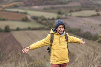 Smiling young woman standing on field
