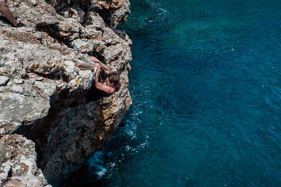 High angle view of young woman on rock