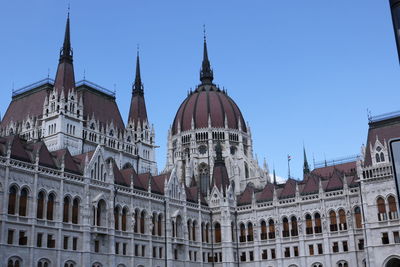 Low angle view of hungarian parliament building against clear blue sky