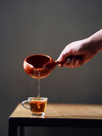 Close-up of hand pouring drink in glass