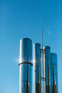 Low angle view of smoke stack against blue sky