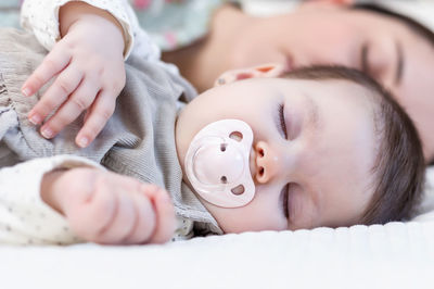 Close-up of baby lying on bed