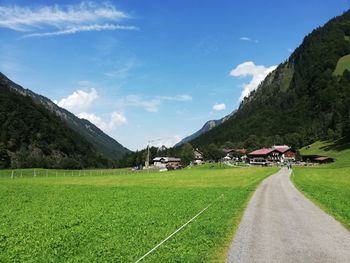 Road amidst field against sky