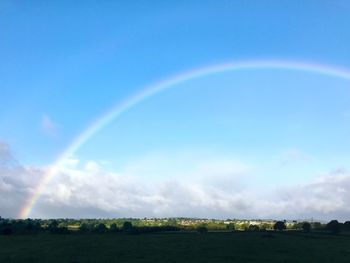 Rainbow over landscape against sky