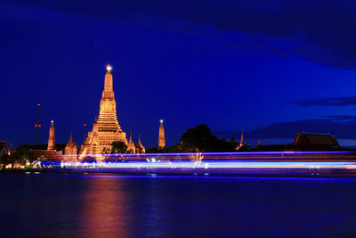 Illuminated building against blue sky at night