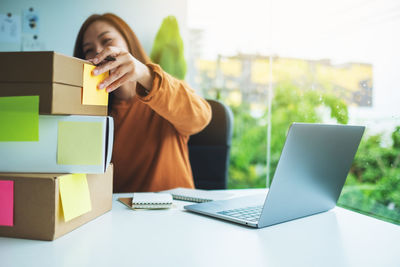 Midsection of woman using laptop on table