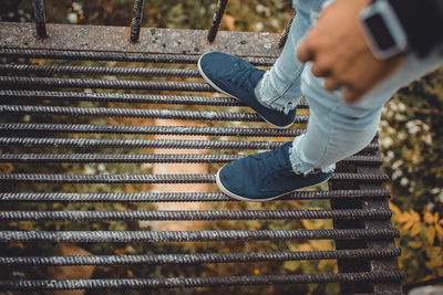 Low section of man standing on metal