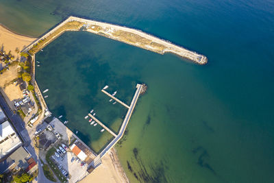 Aerial top view from drone to the seacoast and small marina with boats and yachts.