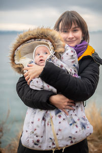 Portrait of mother and girl with arms raised