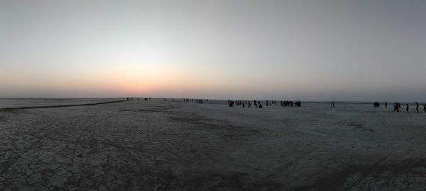 Scenic view of beach against clear sky during sunset