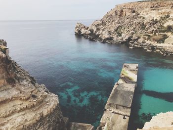 High angle view of rock formation in sea against sky