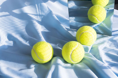 Tennis ball on textile reflecting in mirror