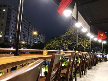 Illuminated street lights on road in city at night