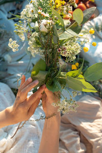 Cropped hand of woman holding plant