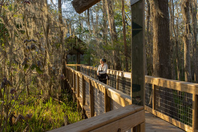 Full frame view of a women enjoying a stroll on a boardwalk above swampy area as the sunlight fades