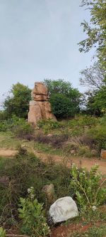 View of cross on rock against sky