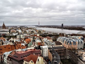 High angle view of city buildings against cloudy sky