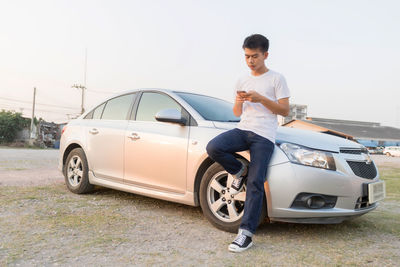 Full length of man standing by car