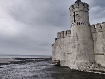 View of old building by sea against sky