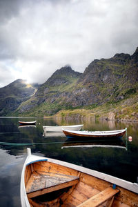 Boat moored by lake against sky