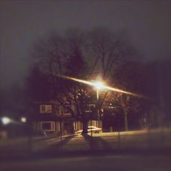 Illuminated street light against sky at night