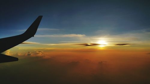 Airplane flying in sky during sunset