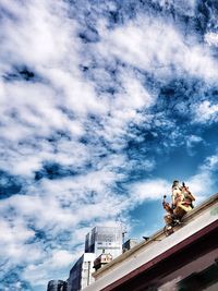 Low angle view of statue against building against sky