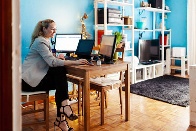 Side view of woman using mobile phone at home