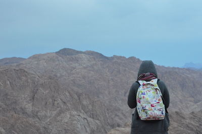 Rear view of woman on mountain against sky