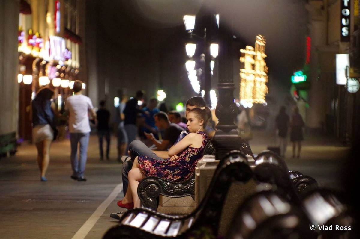 illuminated, night, large group of people, lifestyles, men, person, indoors, leisure activity, crowd, lighting equipment, celebration, arts culture and entertainment, selective focus, city life, focus on foreground, music, standing, street, cultures