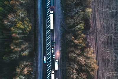 High angle view of vehicles moving on road amidst trees