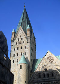 Low angle view of paderborn cathedral against clear blue sky