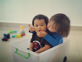 Boy with brother sitting in box at home
