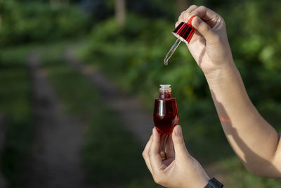 Cropped hand holding bottle