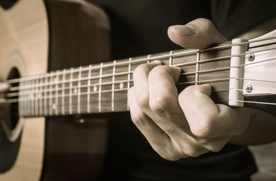 Midsection of man playing guitar