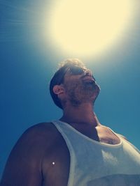 Low angel view of man against sky during sunny day
