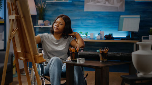 Full length of woman sitting on table