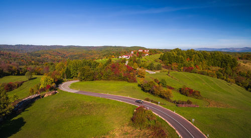 High angle view of road amidst trees against sky