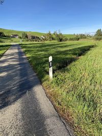 Road amidst field against sky