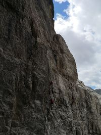 Low angle view of person on rock against sky