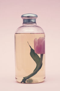 Close-up of glass jar on table against white background