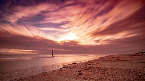 Scenic view of beach against sky during sunset