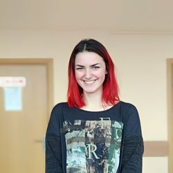 Portrait of smiling young woman standing against wall