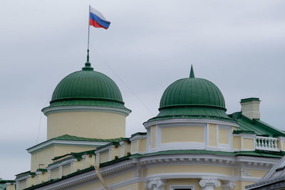 Low angle view of flags on building against sky