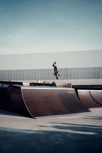 Man skateboarding on skateboard against sky