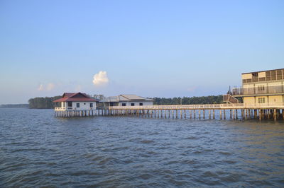 Houses on sea against blue sky