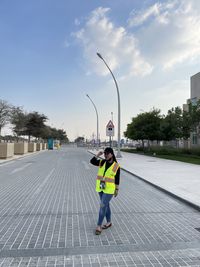 People walking on road against sky