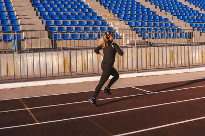 Full length of woman running in stadium